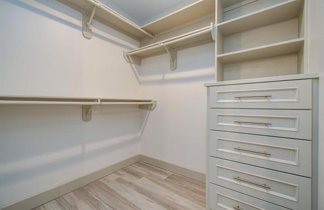 One of two identical closets complete with built-in 5 drawer dresser and shelving. | Image 24