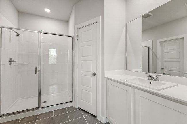 Full bath with a shower stall, vanity, and tile patterned floors | Image 12