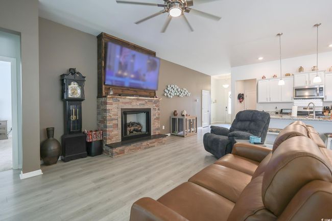 Living area featuring baseboards, light wood-style flooring, and a ceiling fan | Image 4