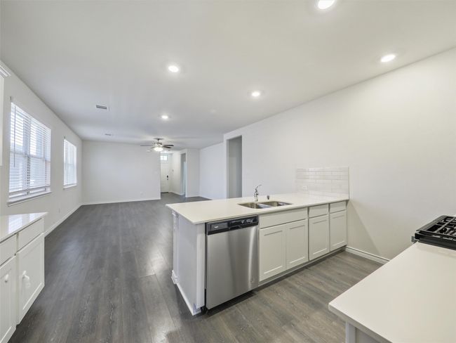 Kitchen featuring dishwasher, a peninsula, a ceiling fan, dark wood-style flooring, and recessed lighting | Image 9