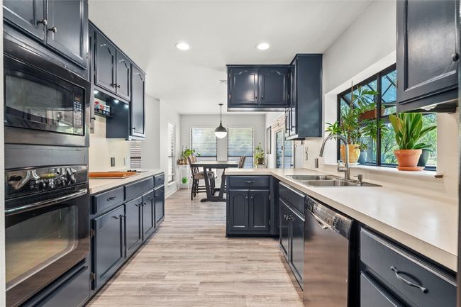 Kitchen featuring black appliances, light countertops, recessed lighting, light wood-style flooring, and pendant lighting | Image 9
