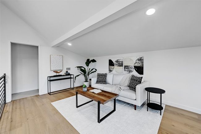 Living room featuring light wood-type flooring and lofted ceiling with beams | Image 15