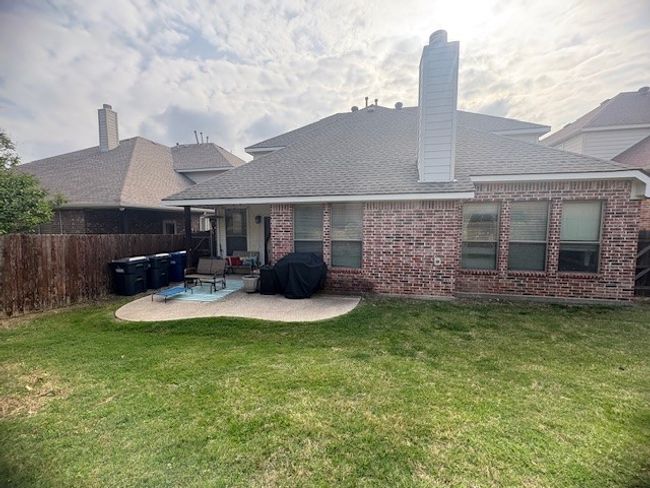 Rear view of property with a patio, roof with shingles, fence, a yard, and brick siding | Image 22