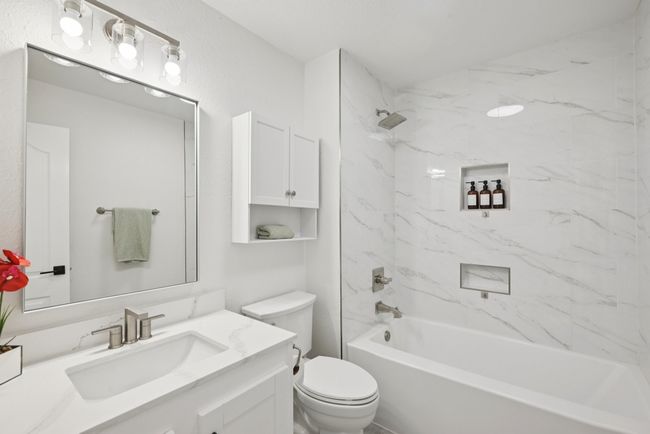Bathroom featuring vanity and washtub / shower combination | Image 36