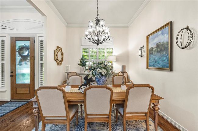 Dining area featuring a notable chandelier, crown molding, and dark wood-type flooring | Image 14