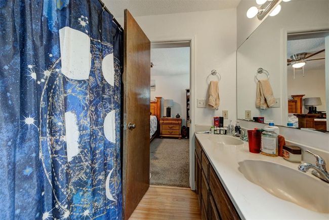 Bathroom featuring a textured ceiling, a sink, double vanity, and ensuite bathroom | Image 9