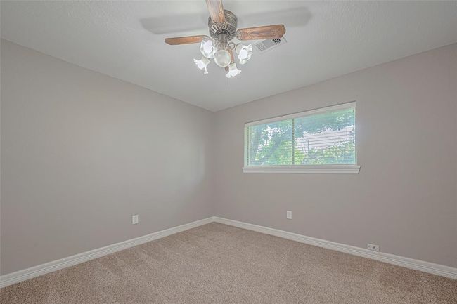 2nd bedroom offers natural lighting from a large window, fan, and ample-sized closet | Image 18