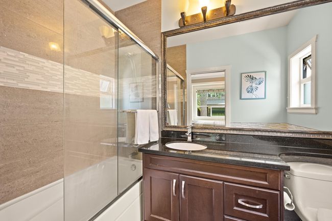 Full bath featuring plenty of natural light, enclosed tub / shower combo, and vanity | Image 17