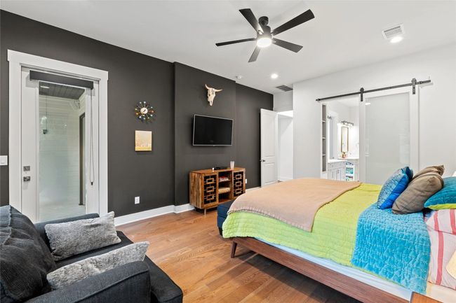 Bedroom featuring a barn door, light wood-style flooring, baseboards, recessed lighting, and a ceiling fan | Image 14