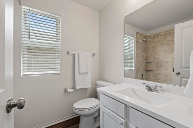 Hall bath with luxury vinyl flooring is located between both secondary bedrooms. | Image 24