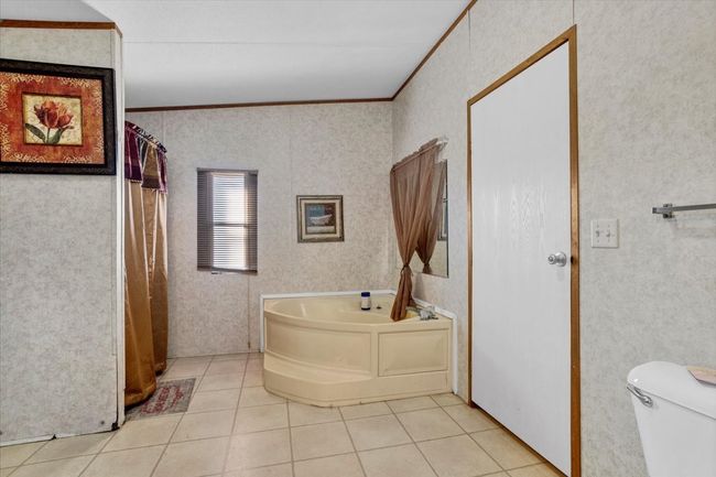 Full bath with a garden tub, ornamental molding, tile patterned flooring, and toilet | Image 15