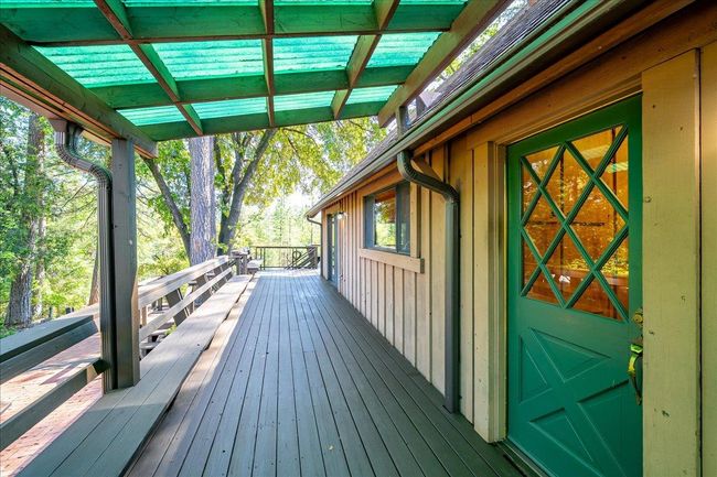 Rear laundry room door leads onto decking overlooking patio and gardens | Image 57