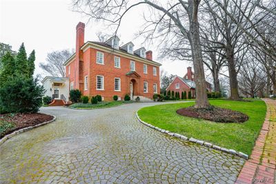 Circular driveway is a fan shaped pattern of pavers with granite cobblestone curbing. Side entrance is to Mud Room. There is a walkway to the rear service area and garden shed. | Image 3