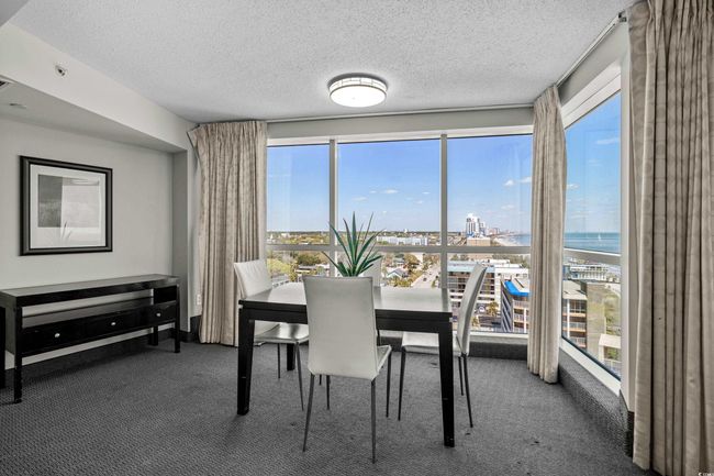 Carpeted dining space with a textured ceiling and a city view | Image 9