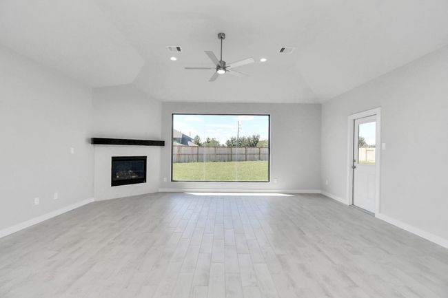 Welcome family and guests to your charming living room! With its high ceilings, recessed lighting, ceiling fan, custom paint, beautiful flooring, and a large window that let in abundant natural light, this room is perfect for gatherings. | Image 19