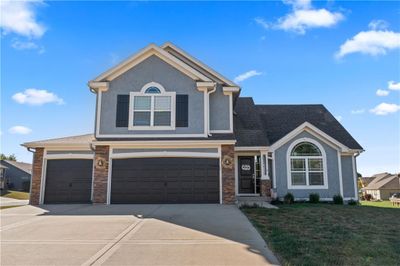 View of front facade with a front yard and a garage | Image 1