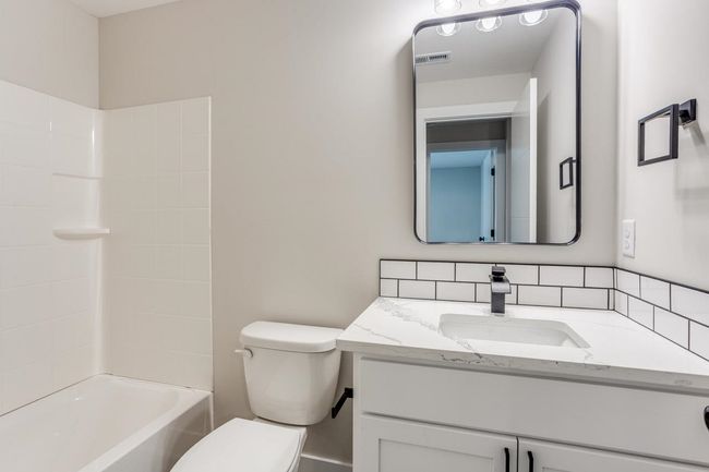 Full bathroom featuring vanity, toilet, shower / bath combination, and decorative backsplash | Image 27