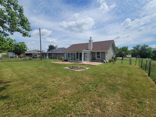 Back of house featuring a sunroom, a chimney, and a gate | Image 24