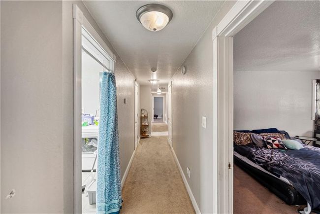Corridor with light colored carpet and a textured ceiling | Image 24