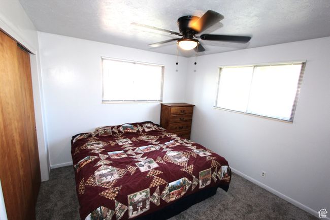 Carpeted bedroom featuring multiple windows, a closet, and a ceiling fan | Image 20