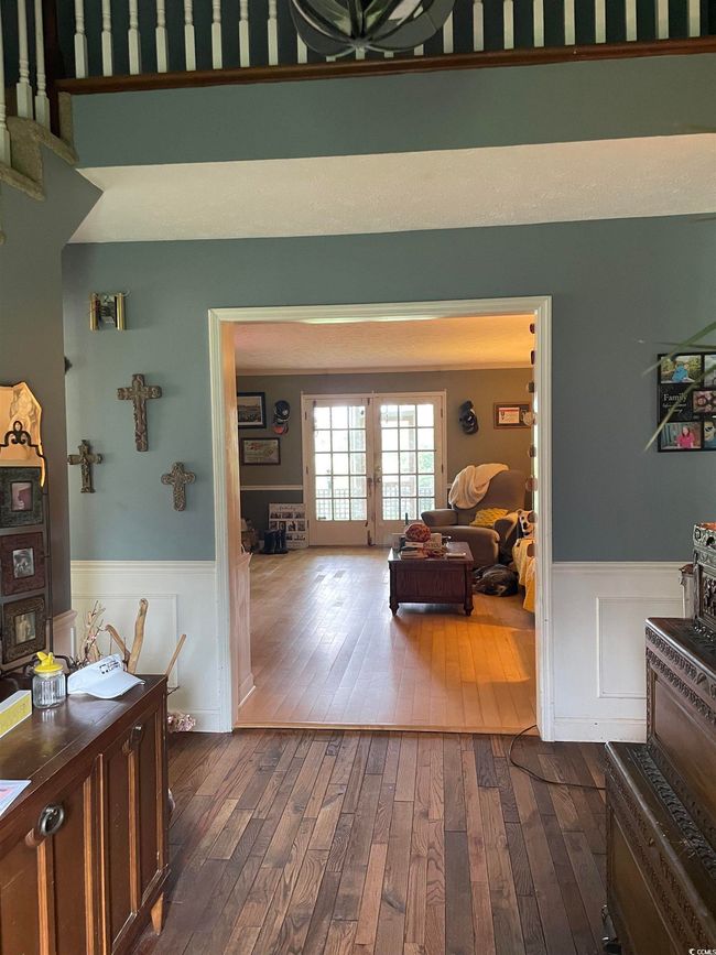 Corridor featuring dark wood-style flooring, wainscoting, and french doors | Image 4