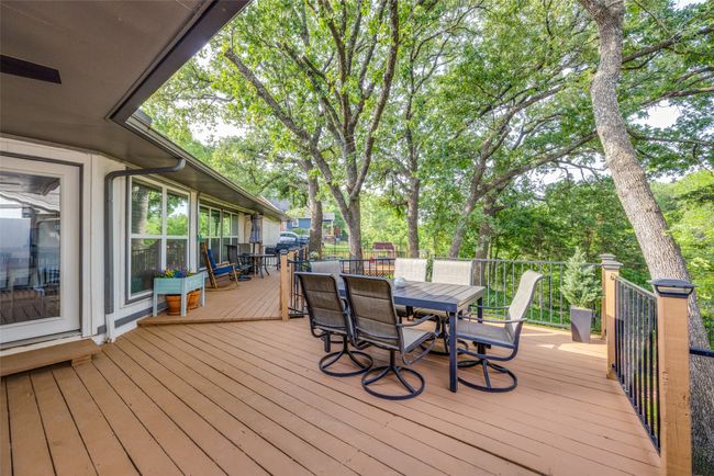 Wooden deck featuring outdoor dining area and view of scattered trees | Image 22