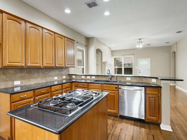 Kitchen with dishwasher, stovetop with downdraft, a peninsula, recessed lighting, and tasteful backsplash | Image 13
