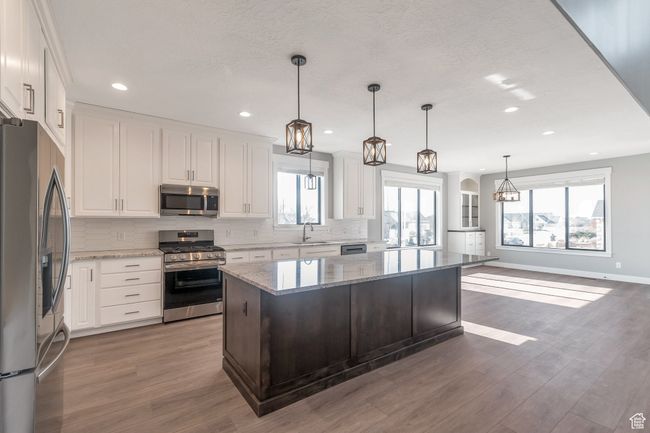 Kitchen featuring stainless steel appliances, tasteful backsplash, white cabinets, and recessed lighting | Image 10