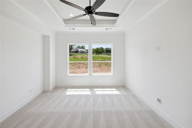 Spare room with light colored carpet, ceiling fan, and a tray ceiling | Image 29