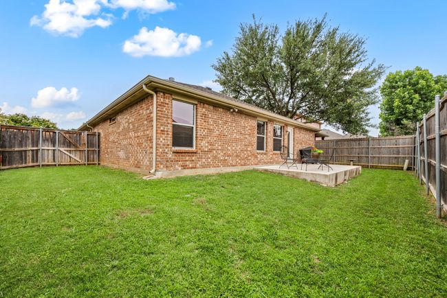 Private backyard with a concrete patio, perfect for outdoor dining or grilling. | Image 33