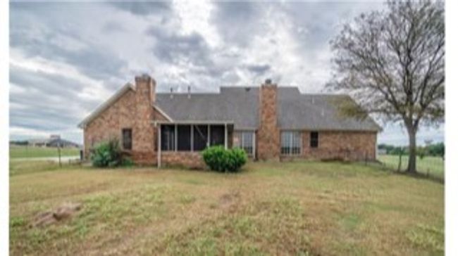 Rear view of property featuring a yard, a chimney, and a sunroom | Image 22