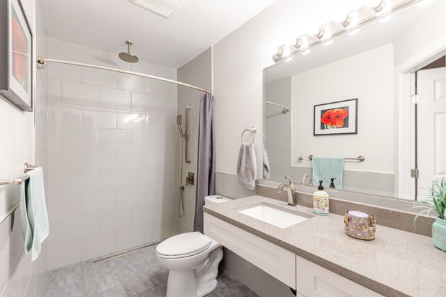 Bathroom with vanity, toilet, and tiled shower | Image 15