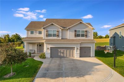 View of front of house featuring a front lawn and a garage | Image 1