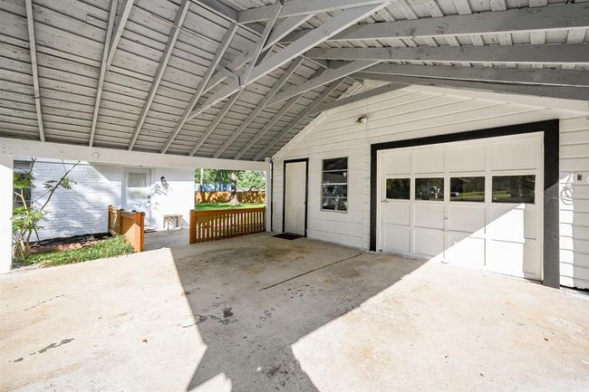 Detached garage, carport, storage room, and work room. A concrete slab, to park a camper or boat, flanks the side of the garage. | Image 31