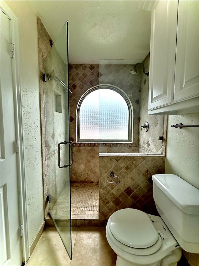 Full walk-in shower with tiled shower, toilet, and added storage | Image 20