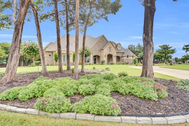 French provincial home featuring stone siding, a front lawn, and brick siding | Image 5