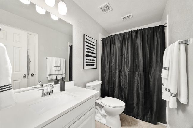 Full bathroom featuring vanity, visible vents, toilet, curtained shower, and tile patterned floors | Image 22