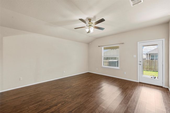 Empty room featuring dark wood finished floors, ceiling fan, and vaulted ceiling | Image 16