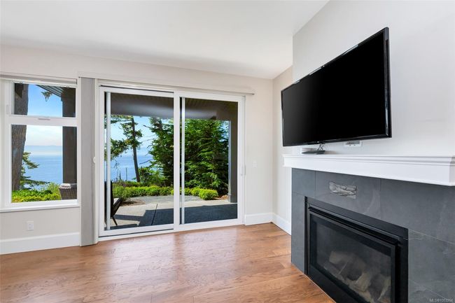 Unfurnished living room with a fireplace and light wood finished floors | Image 53