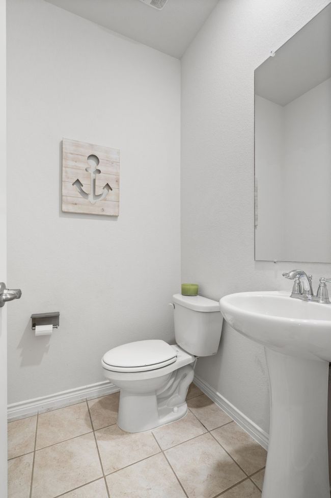 Half bathroom on 1st Floor featuring toilet, tile flooring, baseboards, and a sink | Image 23