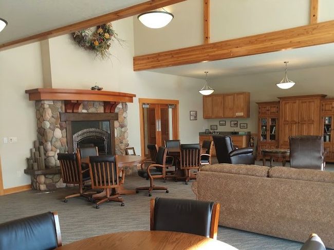 Living room with high vaulted ceiling, a stone fireplace, and beamed ceiling | Image 7