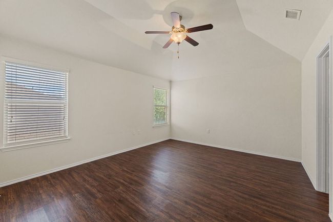 Empty room featuring vaulted ceiling, ceiling fan, and dark wood-type flooring | Image 20