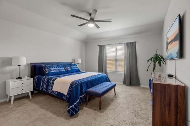 Carpeted bedroom with a ceiling fan and lofted ceiling | Image 13