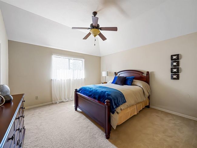 Cozy secondary bedroom with ample natural light and a modern ceiling fan, perfect for comfort and relaxation. | Image 41