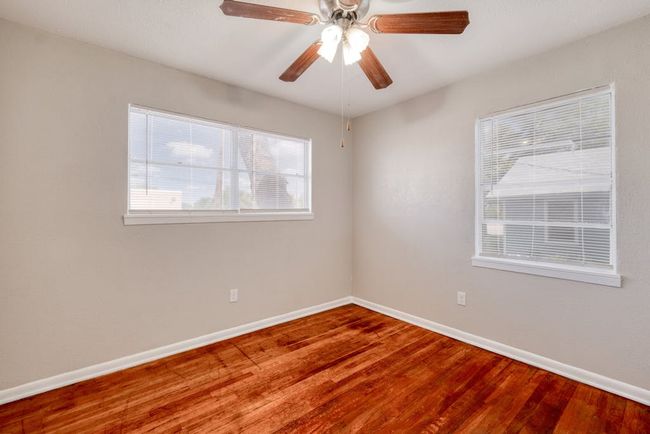 Bedroom 2 featuring ceiling fan, baseboards, and original hardwood floors. Single window was replaced January 2025. | Image 16