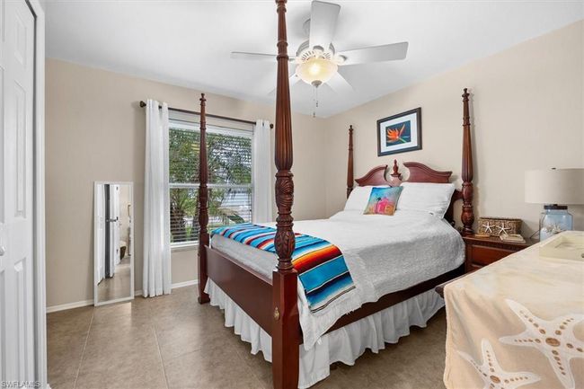 Bedroom featuring ceiling fan, tile patterned floors, and baseboards | Image 9