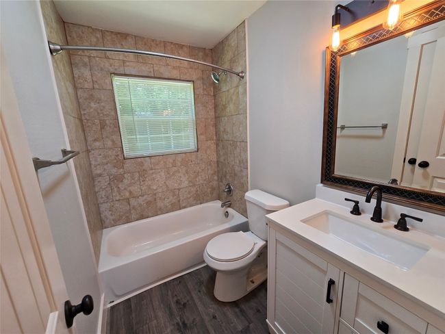 Full bath featuring shower / bathtub combination, wood finished floors, and vanity | Image 8