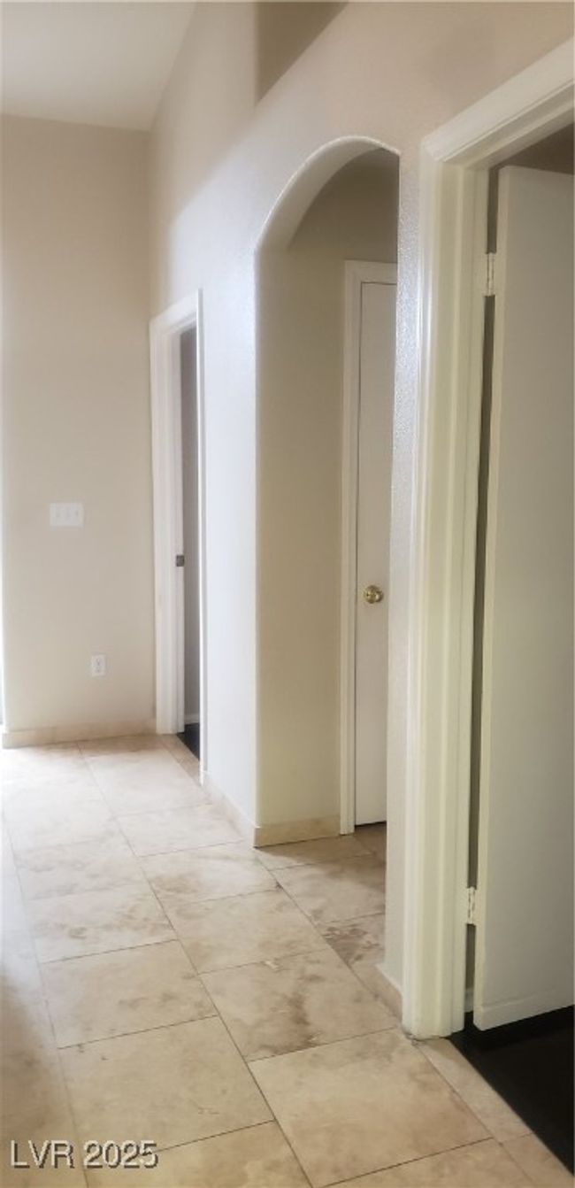 Hallway featuring light tile patterned floors and arched walkways | Image 4