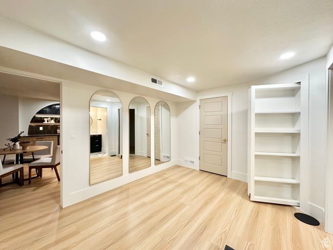 Below grade area with light wood finished floors, recessed lighting, and arched walkways | Image 36