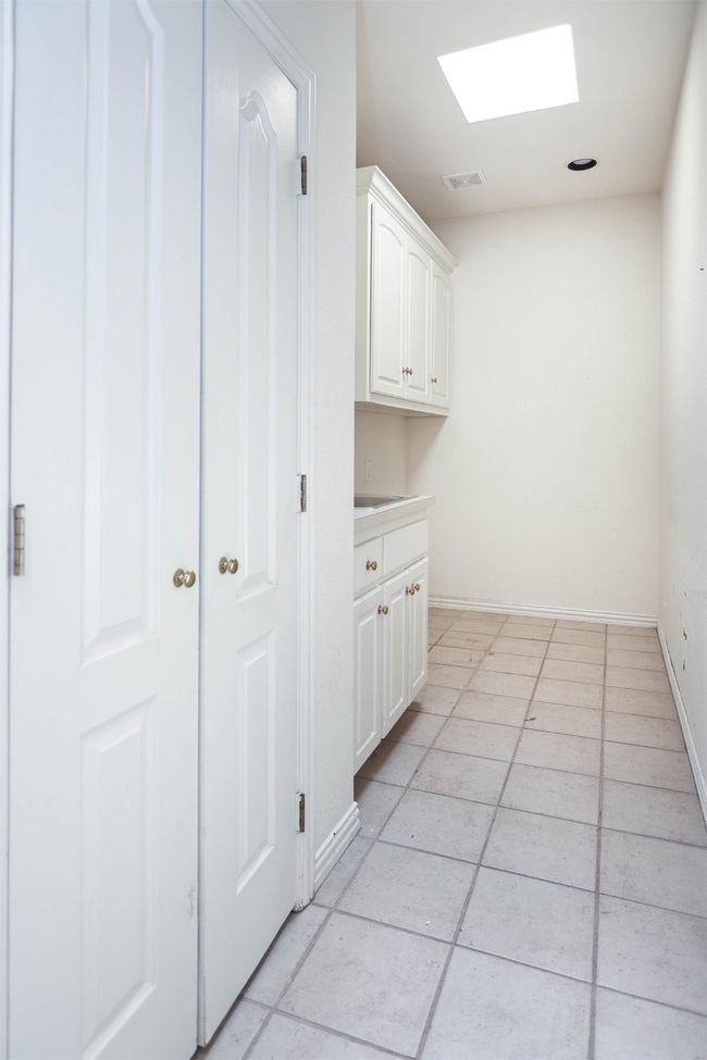 Laundry area with visible vents, a skylight, light tile patterned flooring, and baseboards | Image 18
